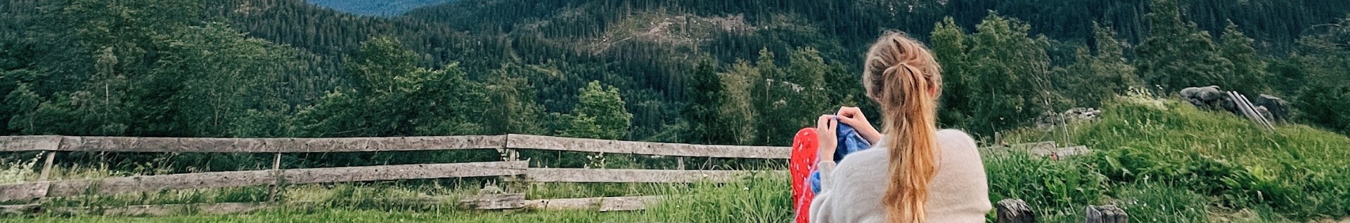 Strikking med utsikt over norske fjell og grønne enger
